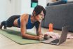 Sporty Woman Doing Plank In Front Of Her Laptop