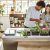 Multi Ethnic Couple Taking Care Of Kitchen Herbs