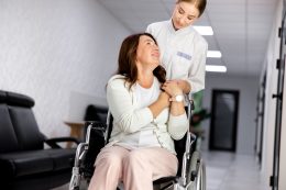 Friendly Nurse Assisting Disabled Woman Stock Photo