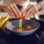 Close Up Of Caucasian Woman Breaking Egg And Making Sunny Side Up Eggs. Domestic Kitchen Interior. Breakfast Preparation.