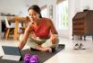 Mixed Race Woman Using Digital Tablet For Yoga Workout At Home