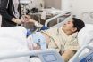 Nurse Preparing Expectant Mother For Cesarean Section In Hospital Ward