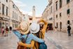 Two Young Female Friends Embracing On The Street In Dubrovnik