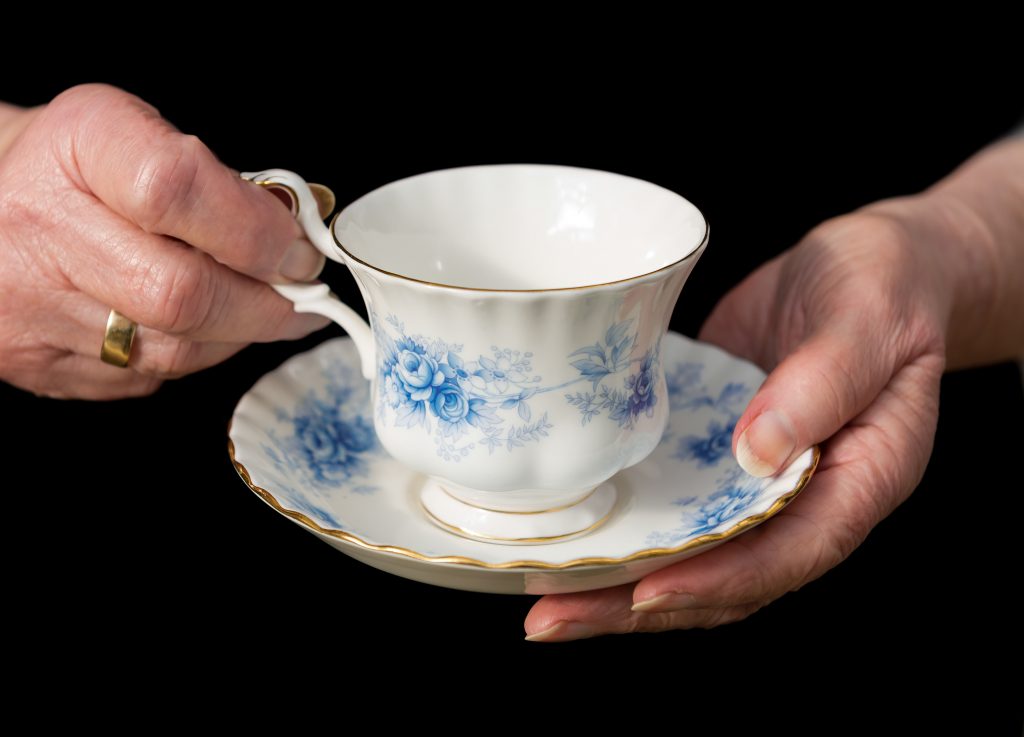 Traditional Teacup And Saucer Held In English Lady's Hands.