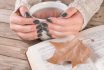 Woman Hands In Sweater With Olive Color Manicure Holds Cup Of Tea And Open Book