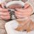 Woman Hands In Sweater With Olive Color Manicure Holds Cup Of Tea And Open Book