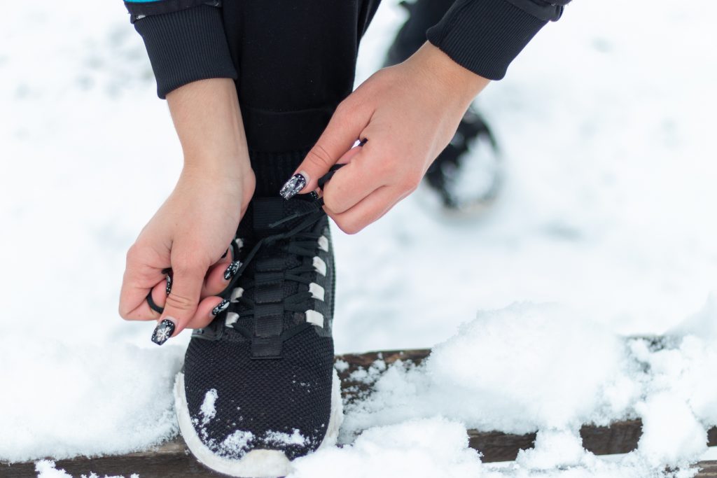 The Girl Tying Running Shoe For Prepare Jogging In Winter Mountains Trail On Snow