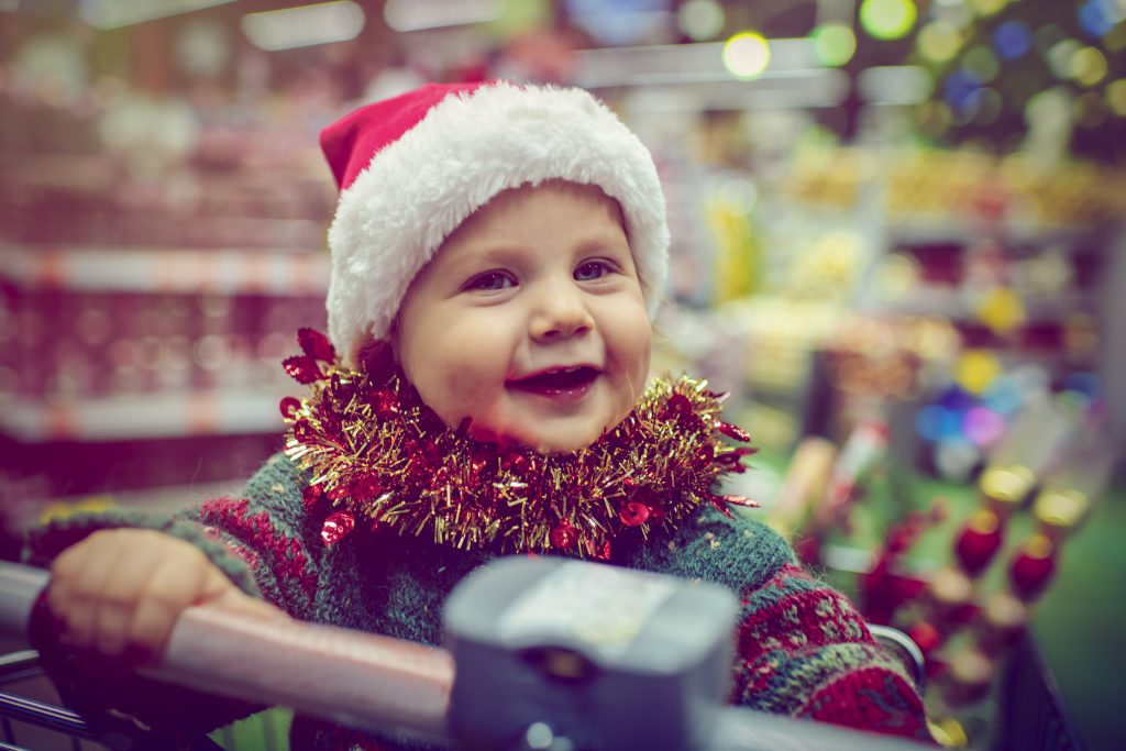 Cute Child In Shopping Cart In Christmas