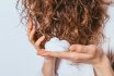 Woman's Hands Apply Styling Mousse To Her Curly Hair