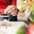 Woman Throwing Effervescent Soluble Pill Into Glass Of Water At Home Near Christmas Tree Closeup