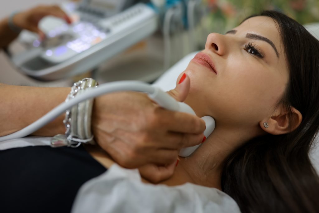 Close Up Shot Of Young Woman Getting Her Neck Examined By Doctor Using Ultrasound Scanner At Modern Clinic S