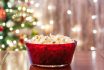 Christmas Eve. Red Bowl With Popcorn On The Table Near Christmas Tree. Home Cinema. Cropped, Close Up