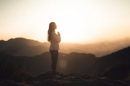 Woman Meditating At Sunset In The Mountains