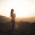 Woman Meditating At Sunset In The Mountains