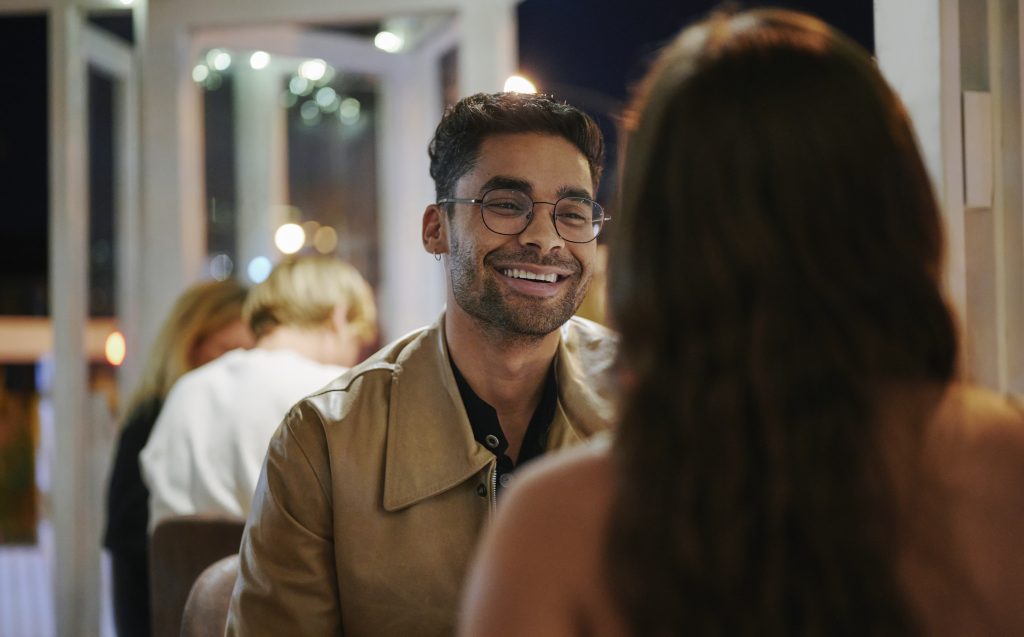 Young Man Laughing While On A Date With A Young Woman In The Evening