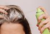 Close Up Of A Young Woman's Head With Dirty Greasy Hair. The Girl Spraying Dry Shampoo On The Roots Of Her Hair