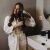 Woman Combing Her Beautiful Hair With Brush While Standing Near Mirror In Bathroom