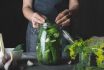 Woman Cooking Marinated Cucumbers With Garlic And Dill On Black. Rustic Dark Style.