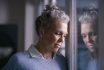 Depression, Sad And Senior Woman By Window Looking, Upset, Lonely And Unhappy In Retirement Home. Mental Health, Loneliness And And Depressed Elderly Female Thinking Of Problem, Issues And Crisis