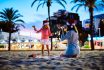 Mother And Daughter Playing With Christmas Lights On The Beach