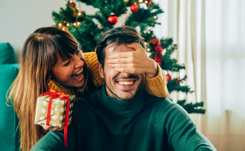 Romantic Young Couple Exchanging Christmas Gifts