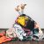 Woman Legs Out Of A Pile Of Clothes On The Floor. Shopping Addiction Concept