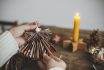 Handmade Christmas Angel From Festive Red Wrapping Paper In Hands On Background Of Rustic Wooden Table With Paper Stars, Candle. Atmospheric Moody Image. Merry Xmas! Holidays Preparation