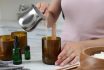 Woman Making Homemade Candle At Table In Kitchen, Closeup