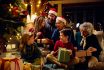 Happy Extended Family Opening Presents By Christmas Tree At Home.