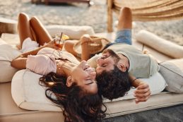 Young Cheerful Couple Having Fun On A Beach Bed.