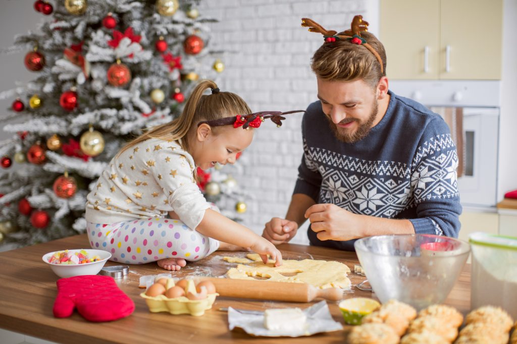 Father And Daughter Baking In Kitchen For Christmas.