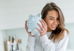 Happy Woman Saving Money In A Piggybank