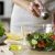 Woman Adding Salt In Vegetable Salad Glass Bowl, Health Care, Excessive Salting