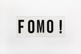 Abbreviation Word Fomo On Transparent Plastic On White. It Means Fear Of Missing Out, Non Stop Internet Surfing. Concept Social Communication Problem Between People, Digital Detox. Flat Lay