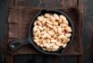 White Canned Beans, In Cast Iron Frying Pan, On Old Dark Wooden Table Background, Top View Flat Lay