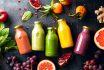 Various Colourful Fresh Raw Ingredients And Already Blended Mix In A Bottles For Individual Consumption Are On The Kitchen Table Surface.