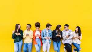 Multiracial Young Friends Having Fun Sharing Media Content On Mobile Phone