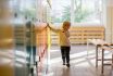 Sweet Blonde Toddler Boy Standing In Front Of A Lockers In Kindergarden Or School Hallway