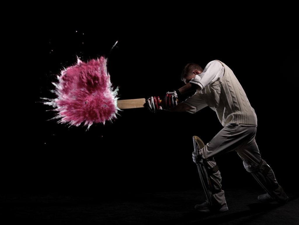 Batsman Hitting Exploding Powder Ball, Side View, Studio Shot