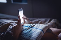 Woman Using Phone Late At Night In Bed. Person Looking At Text Messages With Cell In Dark Home. Hipster Online Dating Or Texting With Smartphone. Sexting Or Cheating Concept.