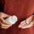 A Woman Pours Pills Or Vitamins From A Jar Onto Her Hand. Taking Vitamins Or Medications. The Concept Of Health Care, Medicine, Pharmacies, Disease Prevention. A Jar With Pills Or Vitamins In The Hand
