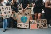 People Are Holding Banner Signs While They Are Going To A Demonstration Against Climate Change