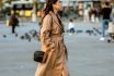 Young Woman Walking On Crowded Street In Trench Coat In Autumn