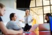 Businesswoman Giving Presentation On Future Plans To Colleagues