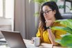 Young Woman Enjoying Her Coffee While Working Or Studying On Laptop Computer At Home Office