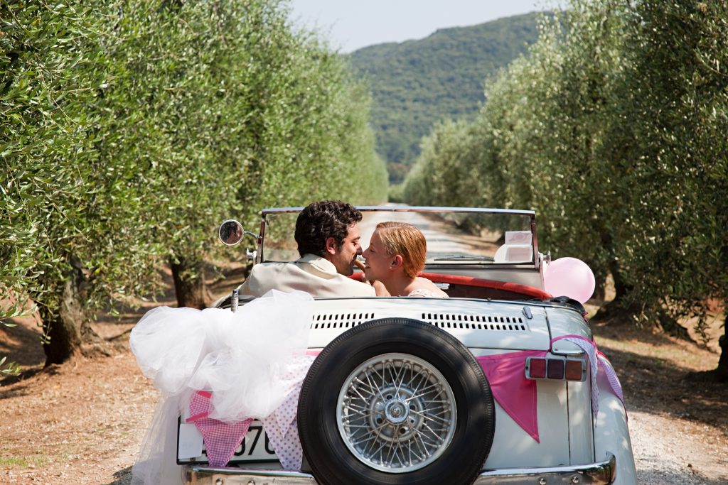 Newlyweds Kissing In Classic Car