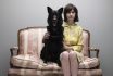 Young Woman And Dog Sitting Side By Side On Love Seat, Portrait