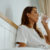 Young Woman Having A Glass Of Water In Bed.