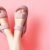 Female Legs In Pink Sandals Upside Down On Pink Background, Copy Space.