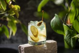 Pickle Juice Or Brine In A Glass And Jar Of Pickled Cucumbers On A Gray Background.